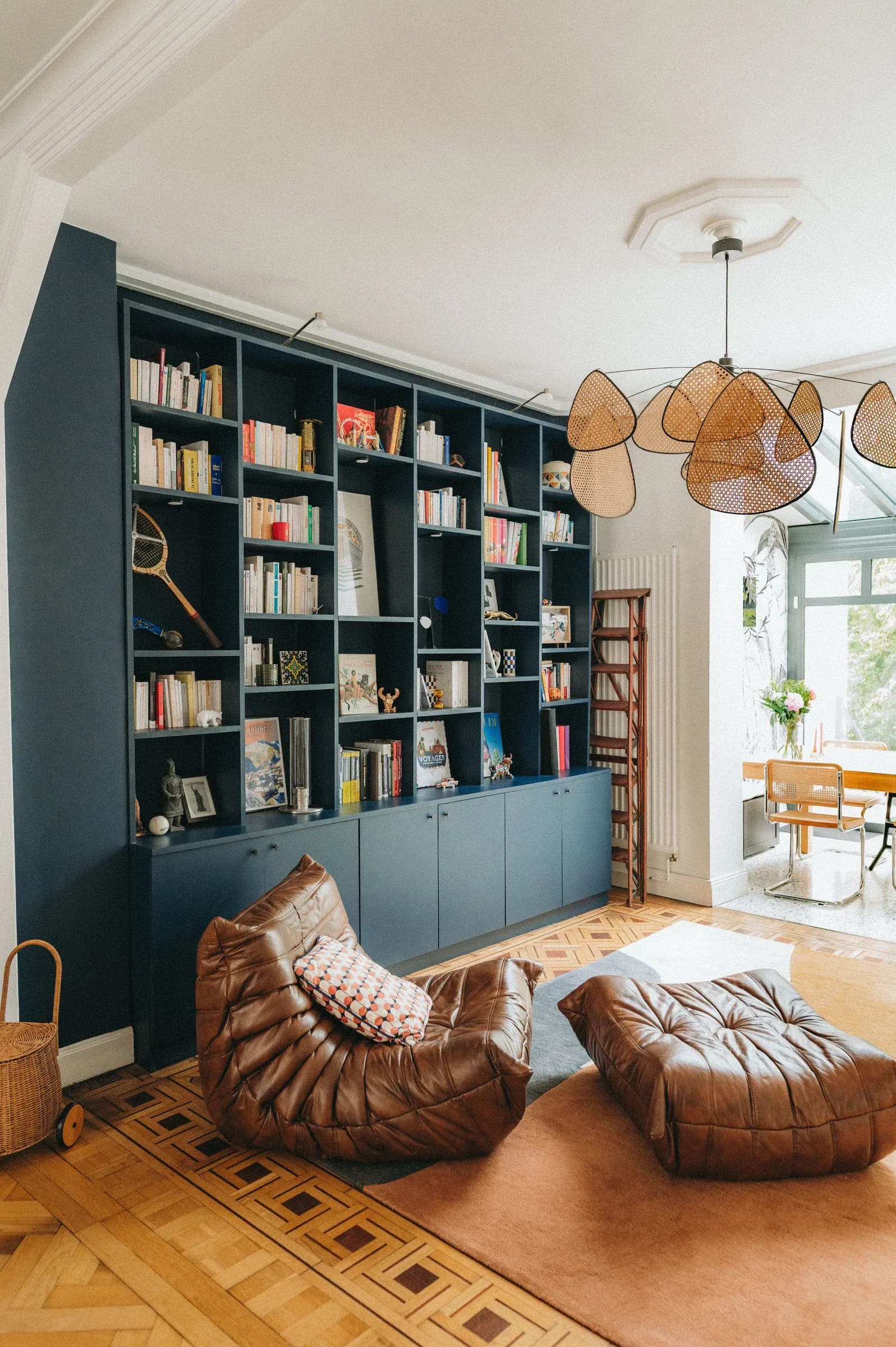 Salon avec bibliothèque bleue sur mesure et fauteuil Togo en cuir