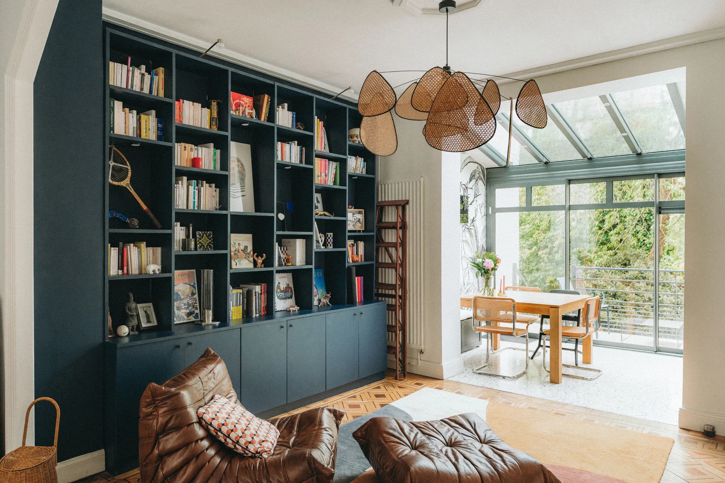 Salon lumineux, bibliothèque bleue et verrière ouvrant sur le jardin